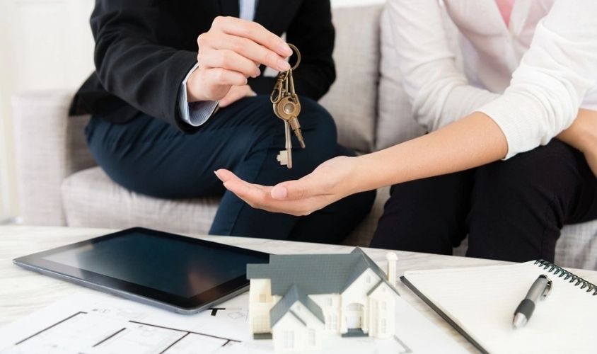 Closeup of Saleswoman Giving House Key